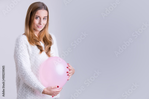 Woman Holding a Balloon to her Belly photo