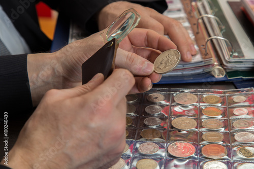 Two numismatists examines  collection of coin