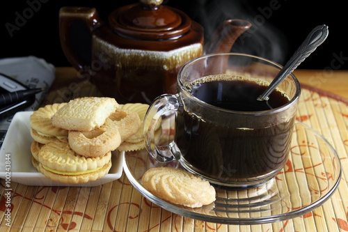 coffee cup with steam and biscuits or cookies closeup