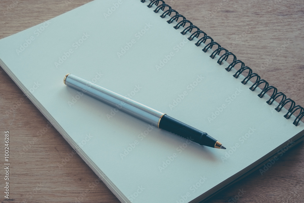 paper notebook and pen on a table with filter effect retro vinta paper notebook and pen on a table with filter effect retro vinta