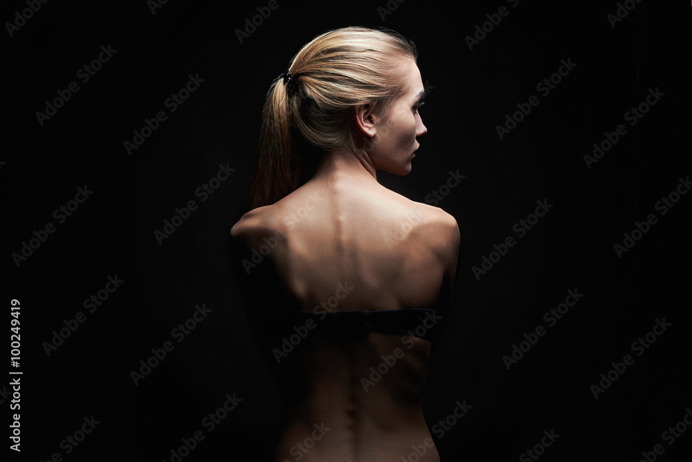 young woman with naked back over black background.sport body girl young woman with naked back over black background.sport body girl