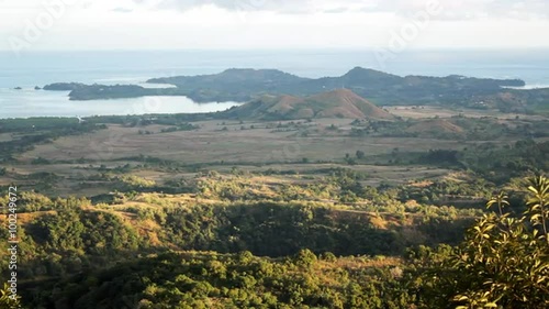 View from the top of a hill overlooking the landscape toward the ocean. photo