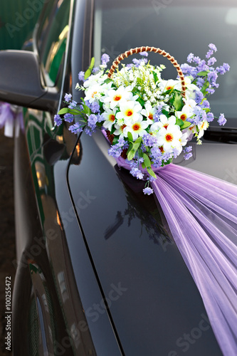 Decorating wedding car basket with flowers.