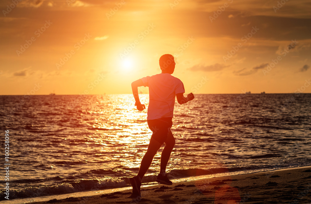 Runner athlete running at seaside. man fitness silhouette sunrise jogging workout wellness concept.