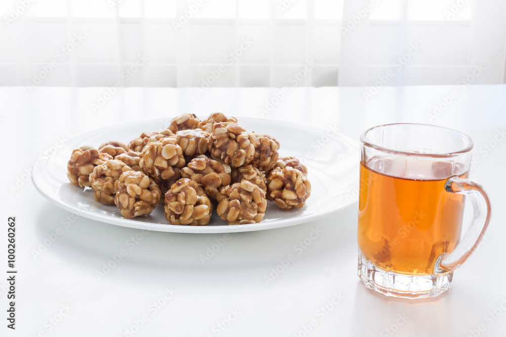 Sweet peanut balls in a plate and glass of black tea Sweet peanut balls in a plate and glass of black tea