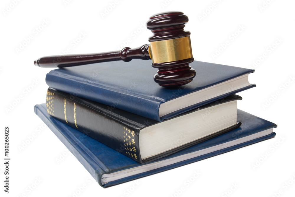 Law book with a wooden judges gavel on table in courtroom Law book with a wooden judges gavel on table in courtroom