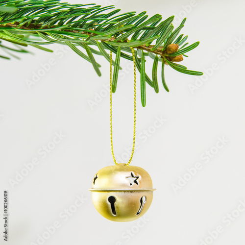 Decorative jingle bell ornament in a Christmas tree photo