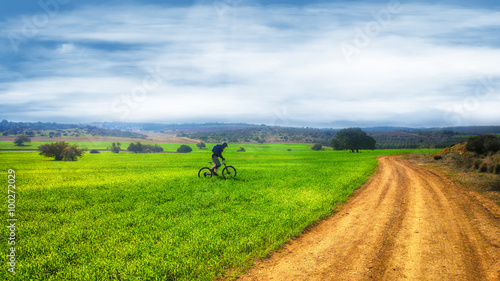 Mountain biking through green fields © Nika Lerman