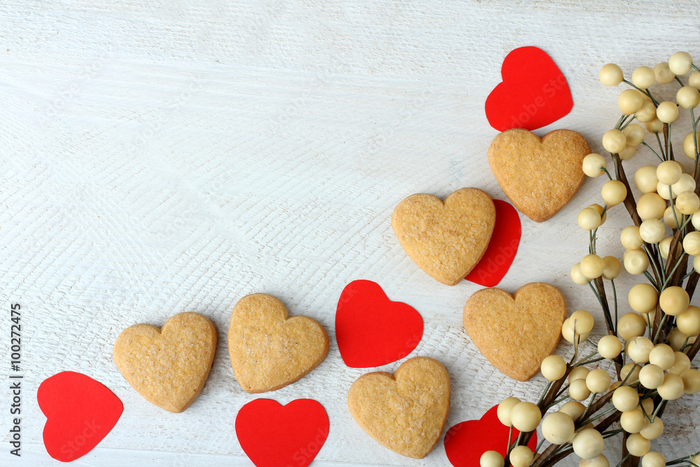 Obraz premium cookies in the shape of a heart and a paper heart on wooden table