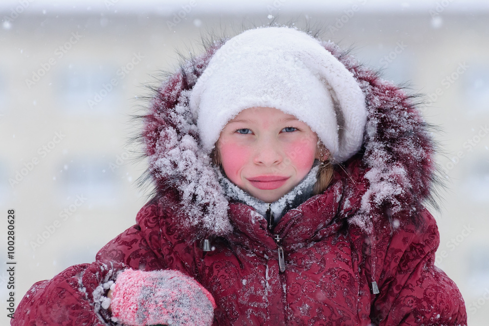 Portrait of a girl in a red down jacket. Portrait of a girl in a red down jacket.