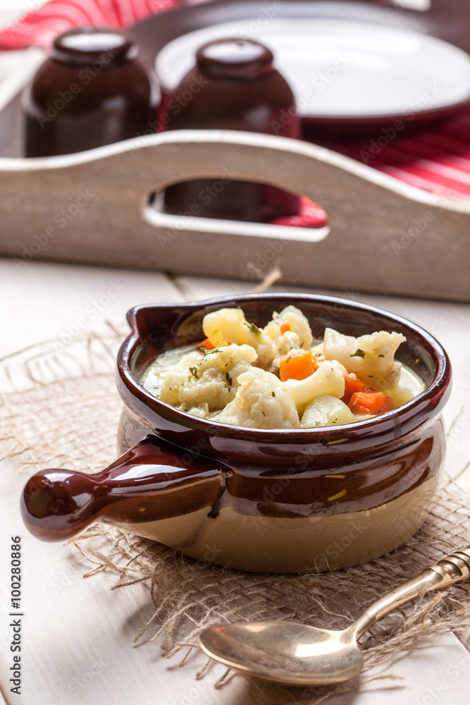 Homemade cauliflower soup in a brown bowl. Homemade cauliflower soup in a brown bowl.