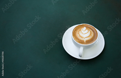 Coffee cup on table with green background
