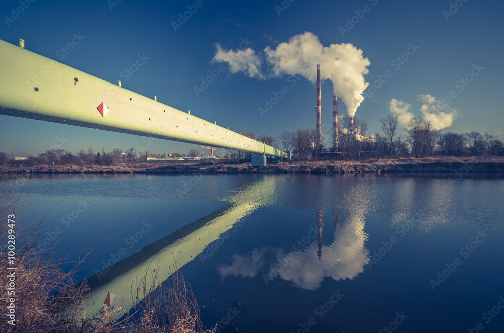 Power plant and overhead pipeline at cold morning over Vistula river, Krakow, Poland