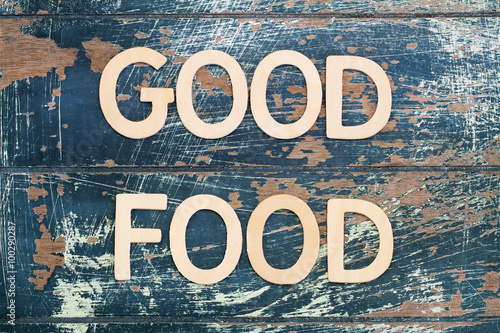 Good food written with wooden letters on rustic surface 