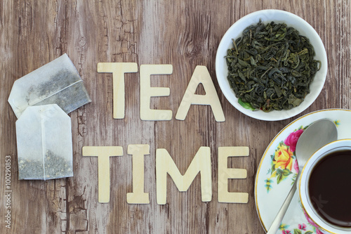Tea time written with wooden letters  tea bags and dried tea leaves  