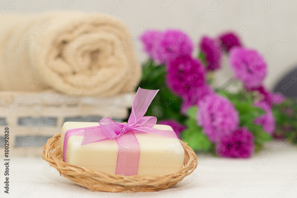 Big piece of beige soap in busket, witn purple bow, flowers on b Big piece of beige soap in busket, witn purple bow, flowers on b