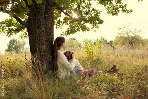 Mother and toddler girl have rest outdoors
