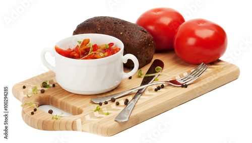 Letcho, tomatoes, black bread on a cutting board