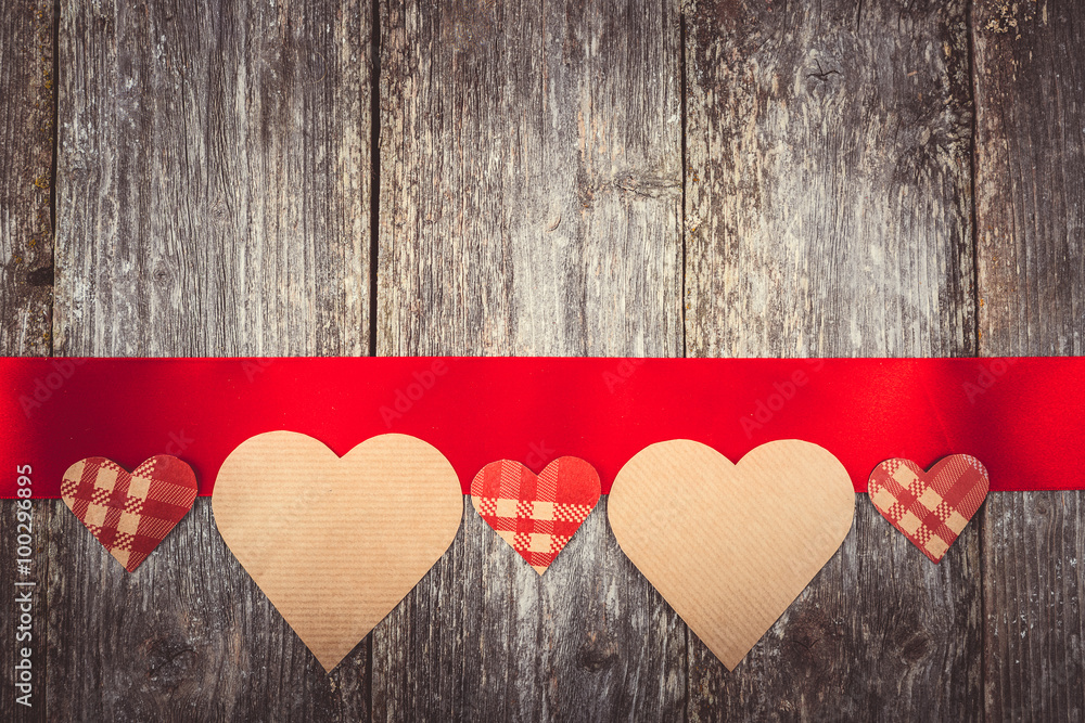 Valentines Day background - many hearts on red ribbon on wooden background. text space. Instagram color toning