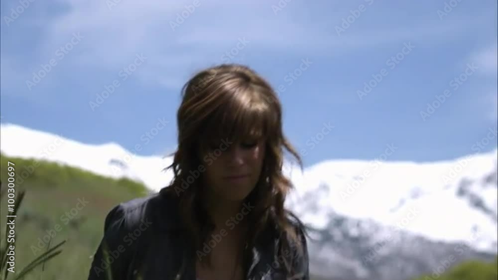 Slow motion shot of a young woman sitting down in tall grass. Slow motion shot of a young woman sitting down in tall grass.