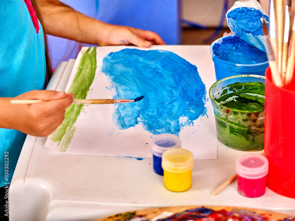 Body part of child hands with brush painting on table in kindergarten . Body part of child hands with brush painting on table in kindergarten .