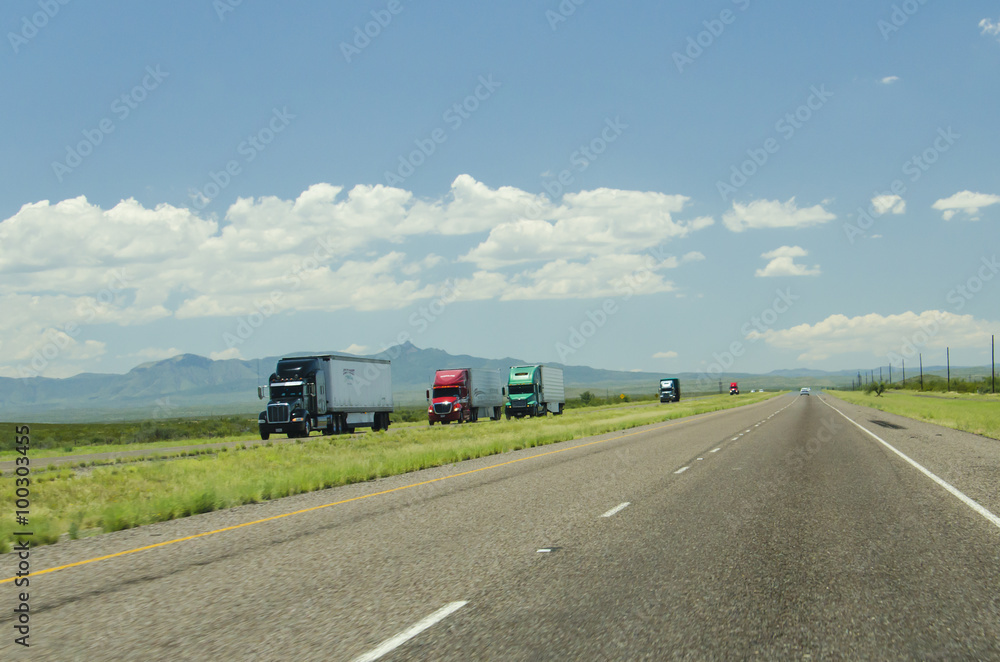 A highway in New Mexico, packed with many truck trailers. 