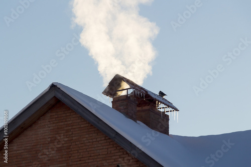 The smoke from the chimney of a private house