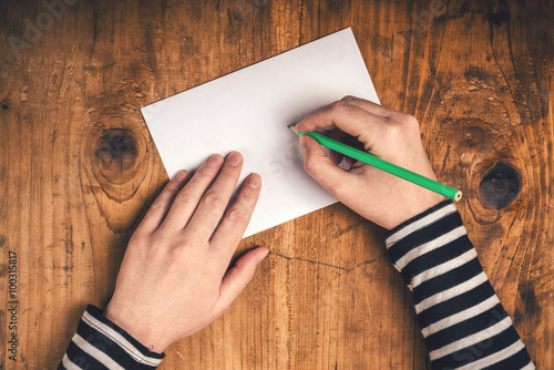 Woman writing recipient address on mailing envelope photo