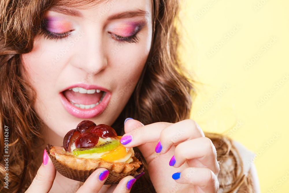Smiling cute woman holds fruit cake in hand