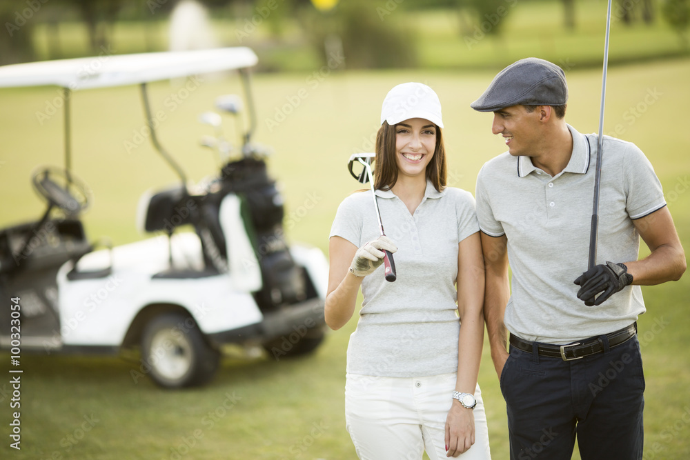 Naklejka premium Young couple at golf cart