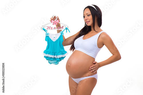 Smiling pregnant woman with child dress for newborn baby girl. Gender of a child