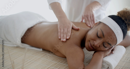 Female therapist's hands doing back massage on woman