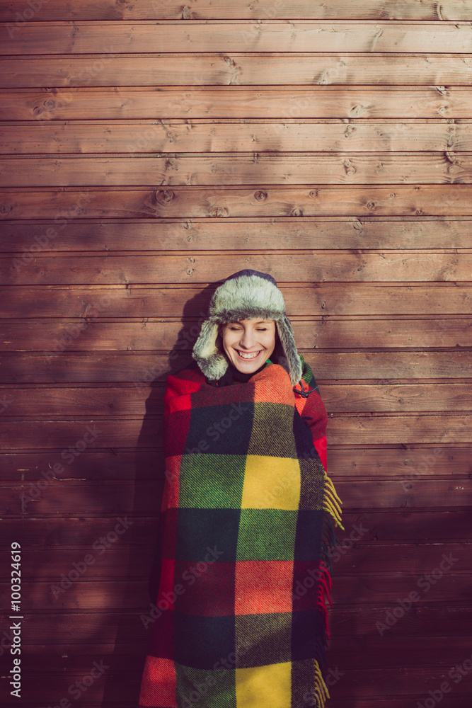 Naklejka premium Young woman resting outdoor, posing under a warm blanket