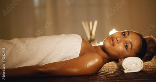 Girl in a towel lies on his back on a massage table