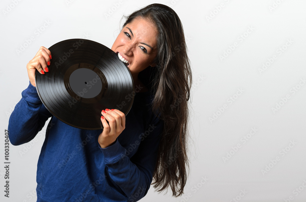 Frustrated woman biting on a vinyl record Frustrated woman biting on a vinyl record