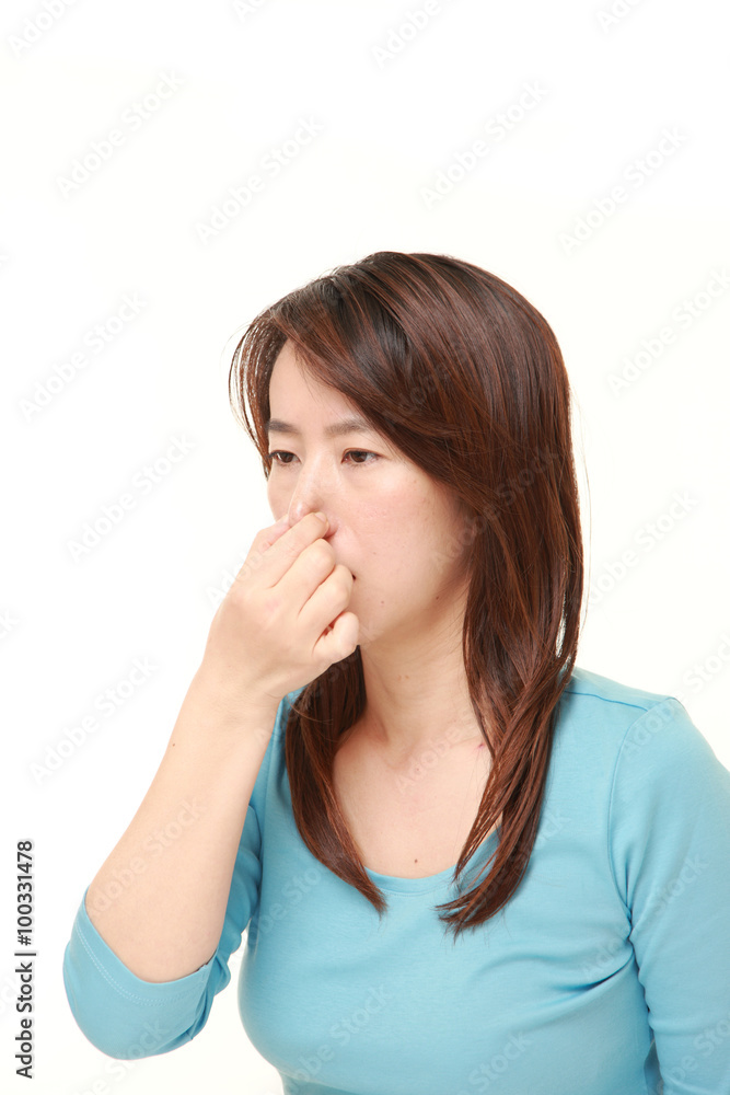 Japanese woman holding her nose because of a bad smell Japanese woman holding her nose because of a bad smell