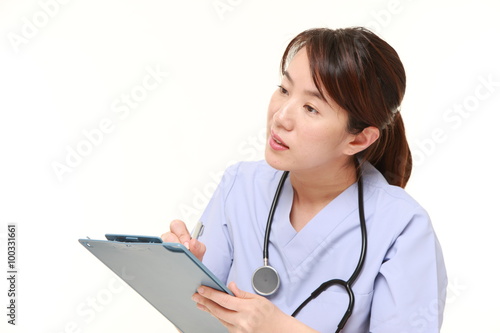 Japanese female doctor fills in clinical record