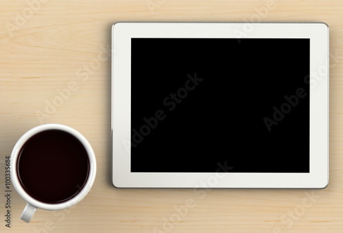 Coffee cup with tablet on wood table