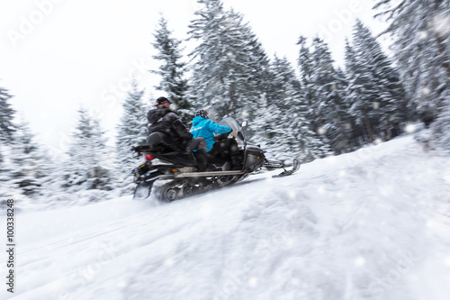 Snowmobile on winter forest road