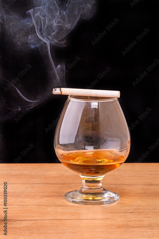 Glass of brandy and smoking a cigarette Glass of brandy and smoking a cigarette