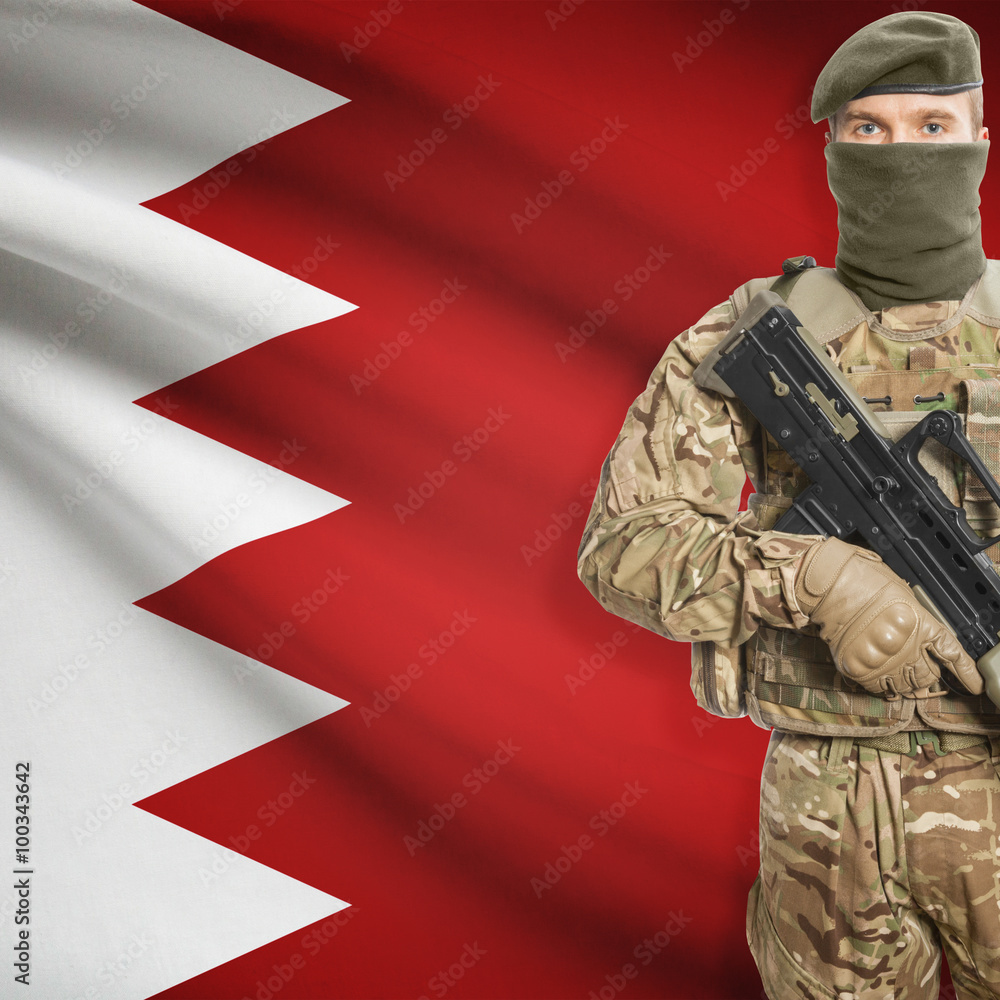 Fototapeta premium Soldier with machine gun and flag on background - Bahrain