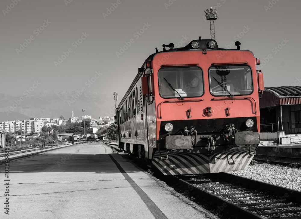 Fototapeta premium Red old train is ready for his journey. / Red old train is waiting on station. City of Split is in background, Croatia.