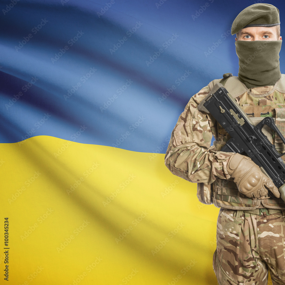 Fototapeta premium Soldier with machine gun and flag on background - Ukraine
