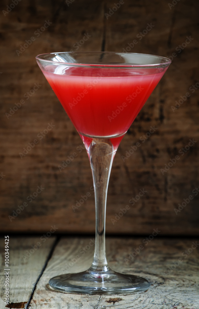 Red margarita cocktail in glass on old wooden background, dark t