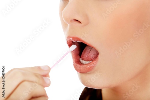 Young woman putting ear stick into mouth