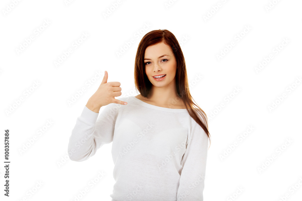 Young woman making a call me gesture Young woman making a call me gesture