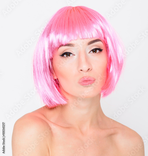 Head shot of sexy young woman in pink wig on white background