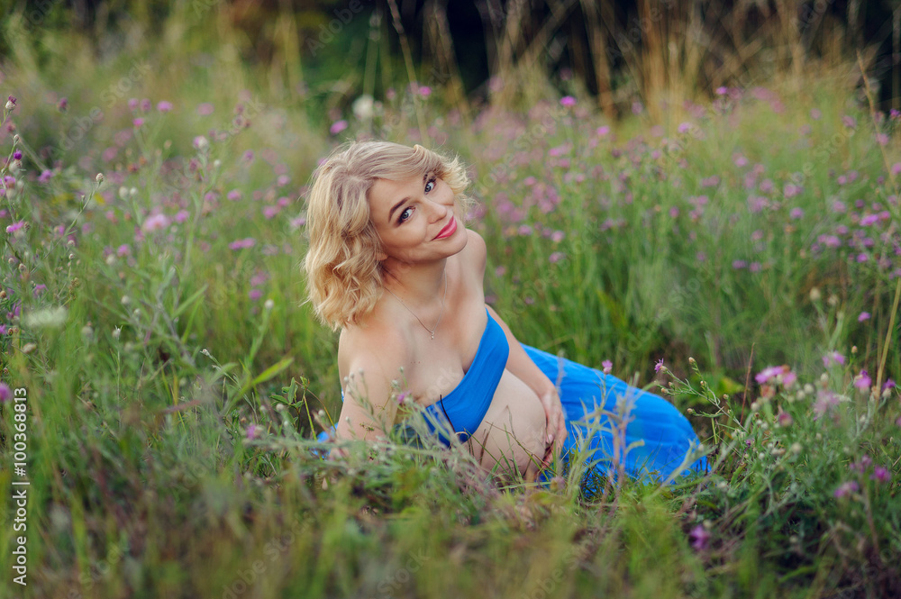 Fototapeta premium Pregnant woman resting on the grass