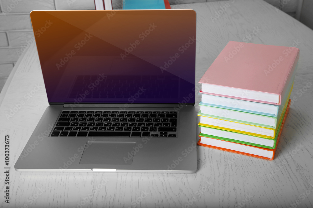 Stack of books with laptop on table close up Stack of books with laptop on table close up