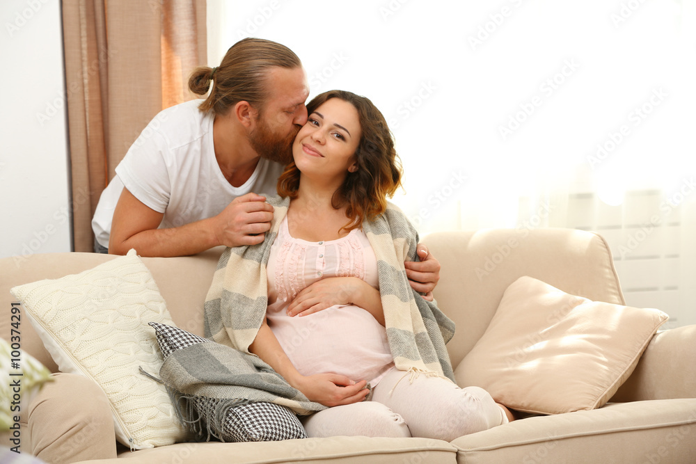 Handsome man takes care about his lovely pregnant woman